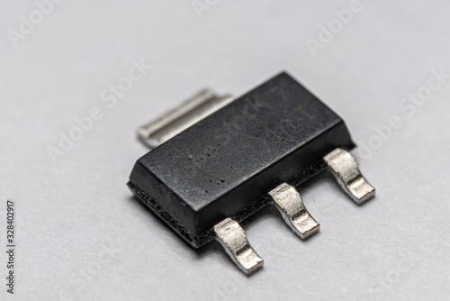 Macro photo of a surface mount (SMD) voltage regulator on a white background.