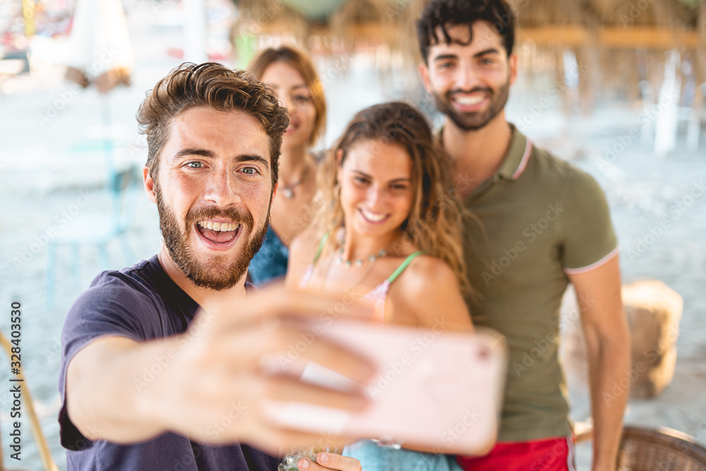 Obraz premium Young friends taking selfie together on beach during summer vacation