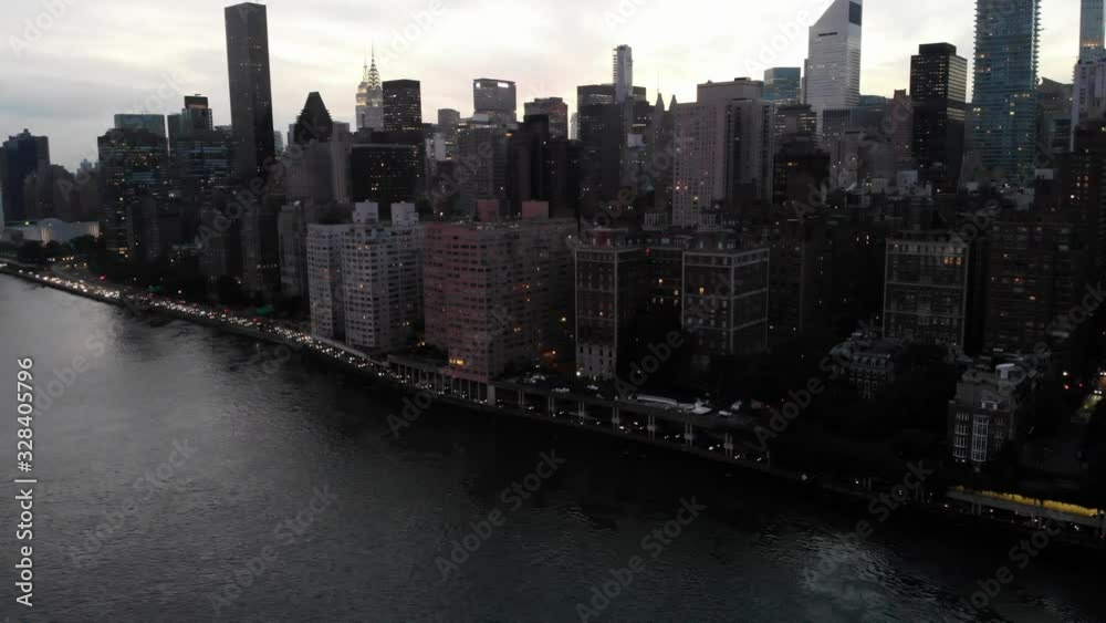 Birds eye view of Manhattan island and modern urban setting in megalopolis - New York, metropolitan landscape of suspension bridge with automotive vehicles during evening time Birds eye view of Manhattan island and modern urban setting in megalopolis - New York, metropolitan landscape of suspension bridge with automotive vehicles during evening time