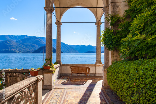 Il portico di una meravigliosa villa sul Lago di Como, Lombardia, Italia, con divano in vimini al tramonto photo