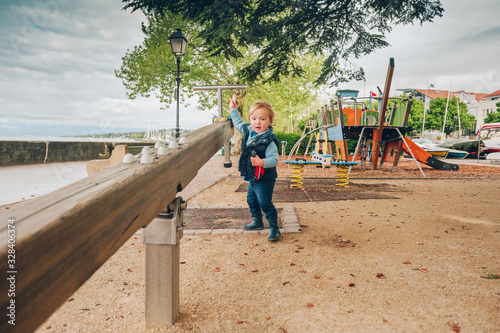 Funny toddler boy having fun on playground