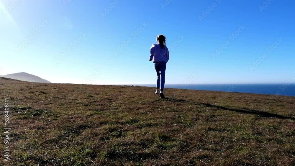 Birds eye view of female tourist exploring wilderness coastline with beautiful seashore, carefree hipster girl with raised hands spending summer vacations near scenic ocean bay enjoying journey Birds eye view of female tourist exploring wilderness coastline with beautiful seashore, carefree hipster girl with raised hands spending summer vacations near scenic ocean bay enjoying journey