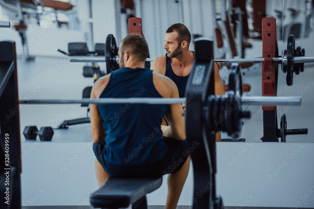 Handsome muscular man working out hard at gym. Training without shirt. Chest exercises. Chest workouts. Handsome muscular man working out hard at gym. Training without shirt. Chest exercises. Chest workouts.