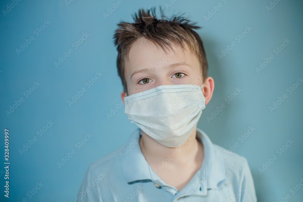 boy in medical mask on blue background. child with flu, influenza or cold protected from viruses, pollution in bad epidemic situation, among patients with coronavirus boy in medical mask on blue background. child with flu, influenza or cold protected from viruses, pollution in bad epidemic situation, among patients with coronavirus