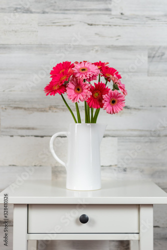 Bright pink bouquet of flowers on white table
