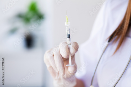 Woman doctor shaking in hands a syringe full