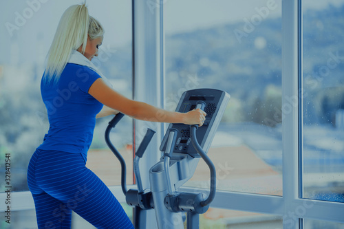 sport, fitness, lifestyle, technology and people concept - woman with or player and earphones exercising on treadmill in gym