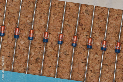 Fotografie Electronic components, Glass molded small signal diode (Cork board textured back
