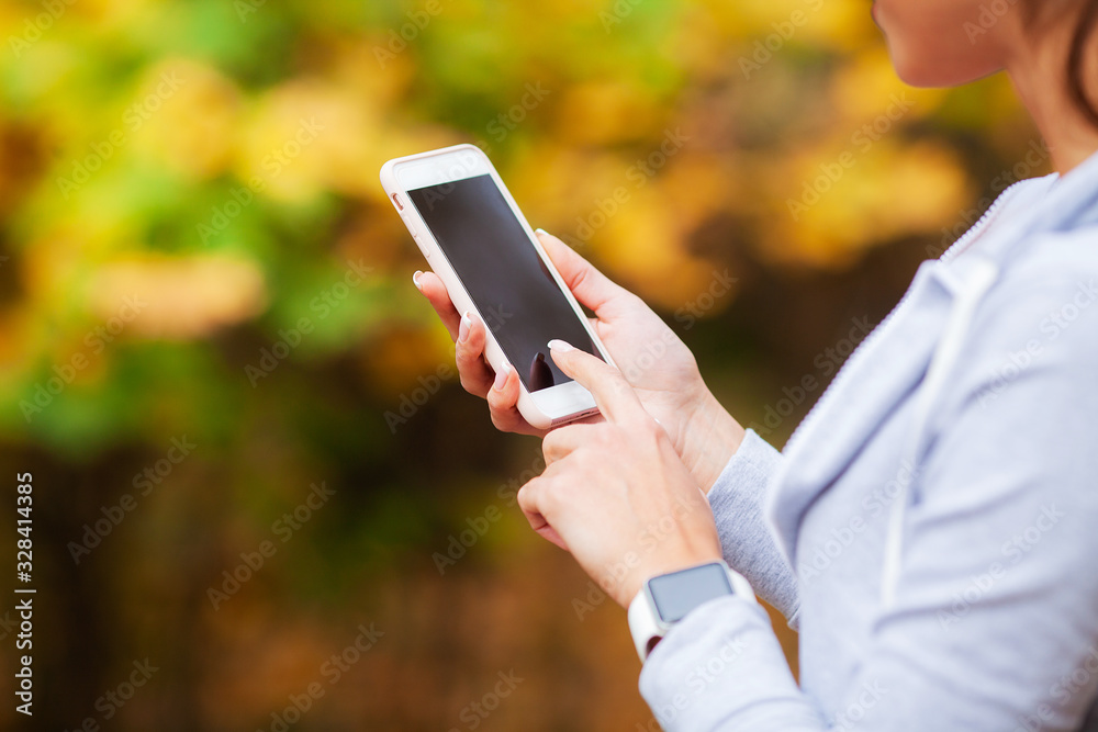 Woman holding in hand phone close up outdoors