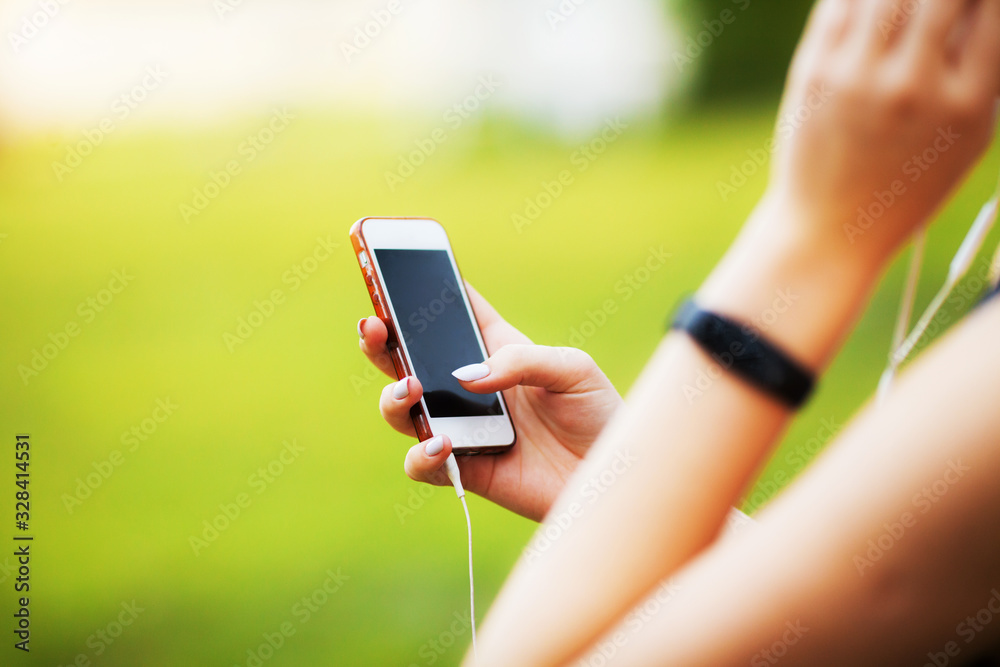 Woman holding in hand phone close up outdoors