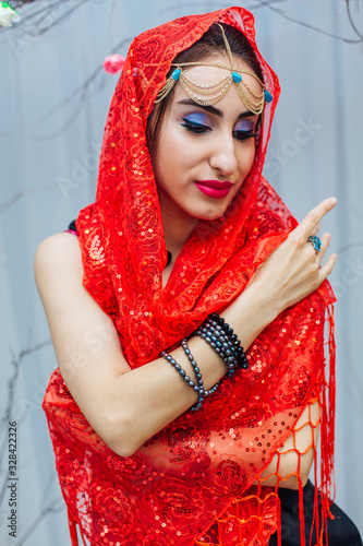 Beautiful eastern woman with makeup and jewelry wearing headscarf.