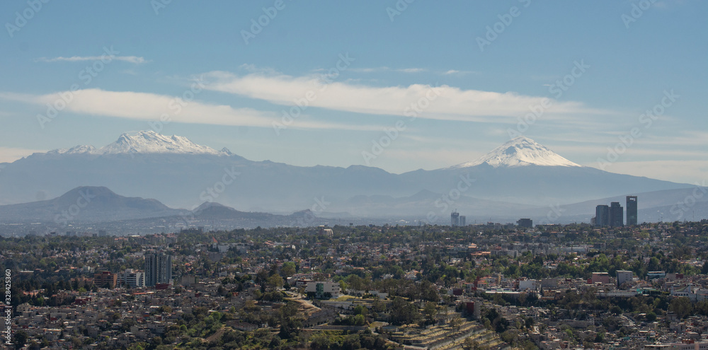 Paisaje urbano de la ciudad de mexico, desde donde se ven los volcanes Iztaciuatl y Popocatepetl