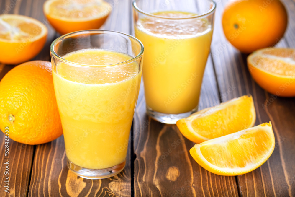 Two glass of fresh orange juice with fresh fruits on wooden table. Healthy drink and food. Two glass of fresh orange juice with fresh fruits on wooden table. Healthy drink and food.