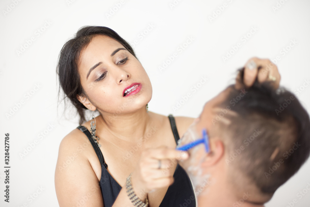 Attractive Indian Bengali brunette couple seductive foreplay in black dress in a white bedroom while the girl is shaving the man in a seductive way. Indian lifestyle Attractive Indian Bengali brunette couple seductive foreplay in black dress in a white bedroom while the girl is shaving the man in a seductive way. Indian lifestyle