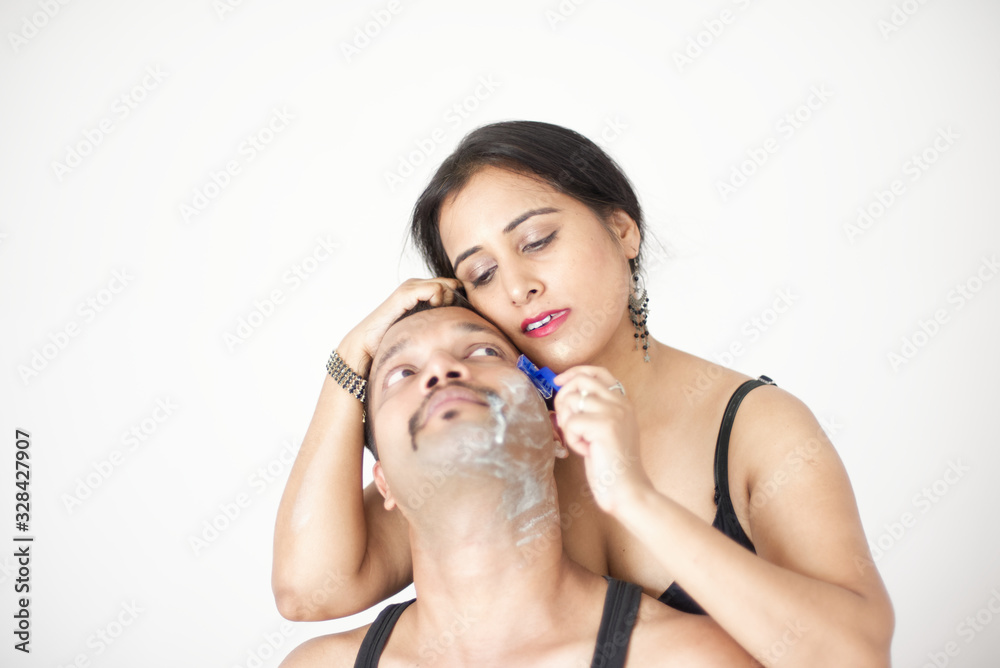 Attractive Indian Bengali brunette couple seductive foreplay in black dress in a white bedroom while the girl is shaving the man in a seductive way. Indian lifestyle Attractive Indian Bengali brunette couple seductive foreplay in black dress in a white bedroom while the girl is shaving the man in a seductive way. Indian lifestyle