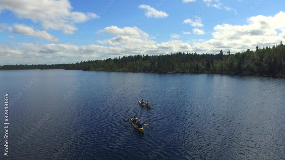Drone fly over shot of canoers on a big Swedish lake and the beautiful sky with cloud formations Drone fly over shot of canoers on a big Swedish lake and the beautiful sky with cloud formations