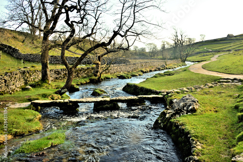 Downstream View of Malham Beck with the Old Stone Clapper Bridge photo