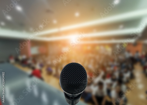 Microphone over the Abstract blurred photo of conference hall or seminar room with attendee background,Small Business training concept,Public speaking