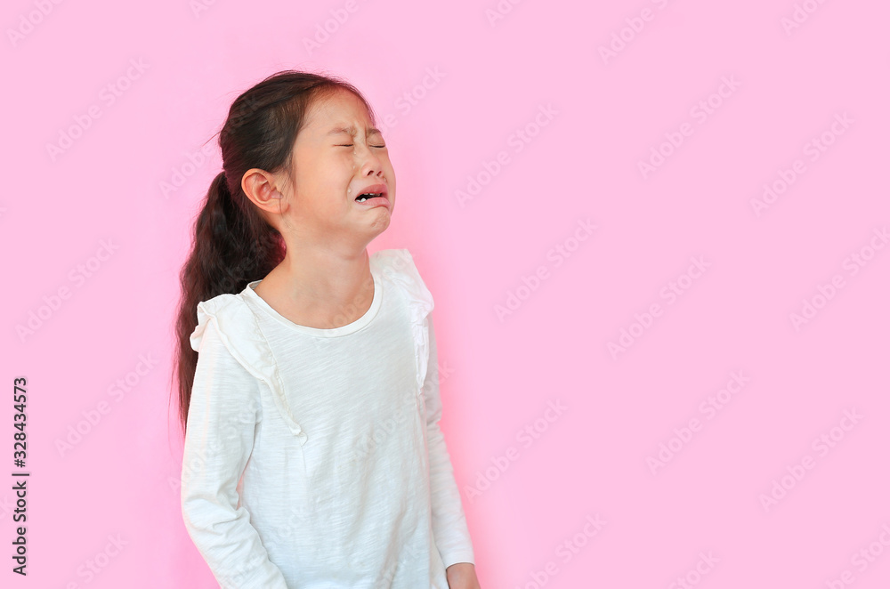 Portrait asian little child girl crying isolated on pink background with copy space. Kid with sad expressions. Portrait asian little child girl crying isolated on pink background with copy space. Kid with sad expressions.