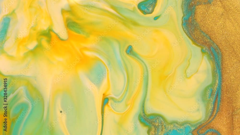 Light blue and gold liquid glitter paint mix. Abstract background. A real beautiful substance flows. Motion mixed colorful ink macro 