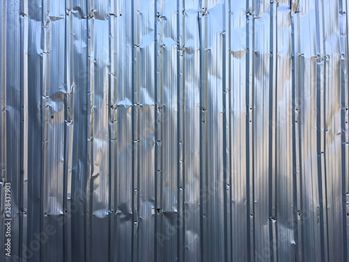 Crumpled Corrugated metal texture or Galvanized iron steel background, shiny fence, Silver Colour