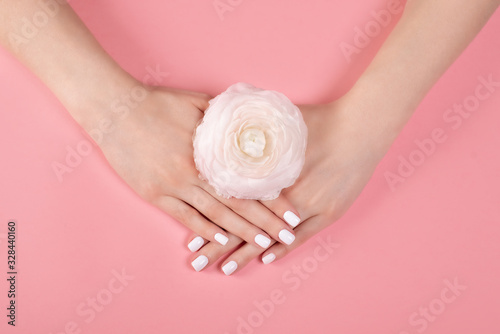 Hands of a beautiful woman on a colorful background. Delicate palm with natural manicure  clean skin. Light pink nails.