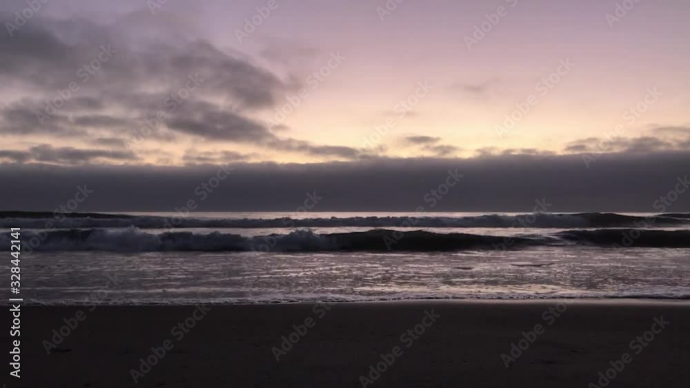View of sea waves at sunset, from a beach.