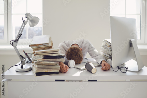 Tired busy businessman sleeping at a table with a computer. photo