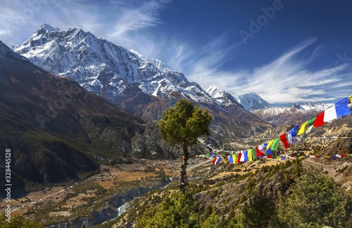 Landscape View of Annapurna 3 Peak (7555 m) in Himalaya Mountain Range and Buddhist Prayer Flags on Annapurna Circuit Trekking Route in Nepal photo