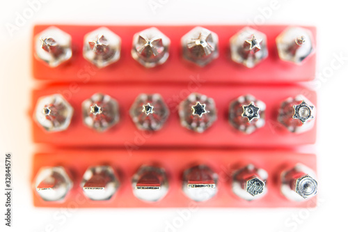 Set of screwdriver bits in a red holder on a white background top view