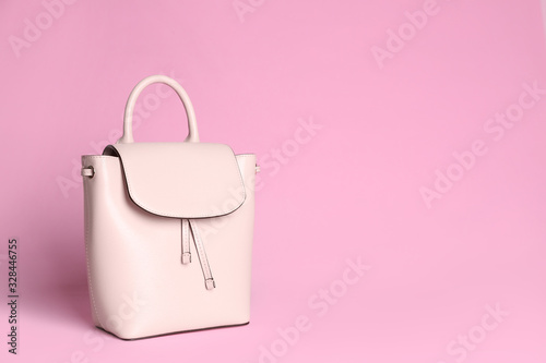 Stylish woman's backpack on light pink background. Space for text
