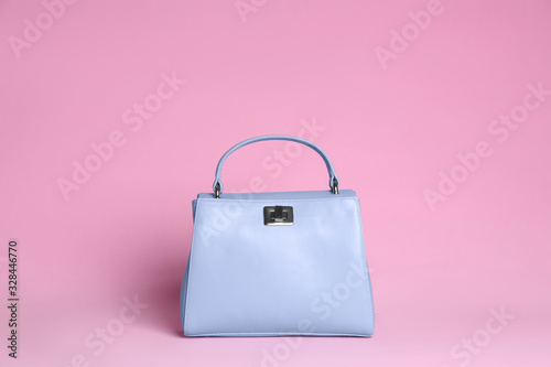 Stylish woman's bag on light pink background