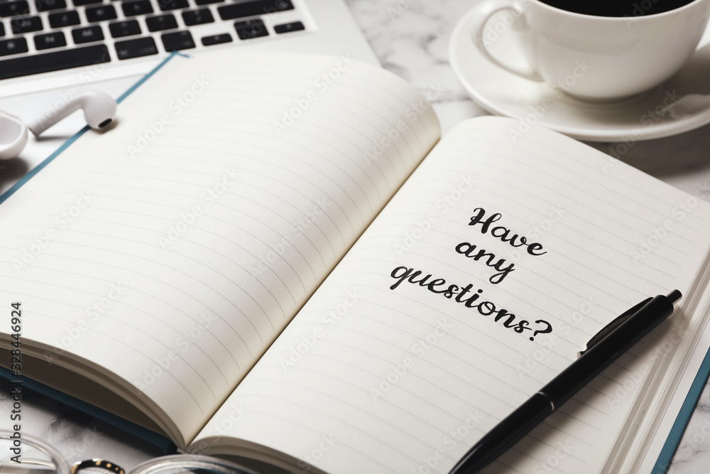 Notebook with phrase HAVE ANY QUESTIONS on white marble table, closeup Notebook with phrase HAVE ANY QUESTIONS on white marble table, closeup