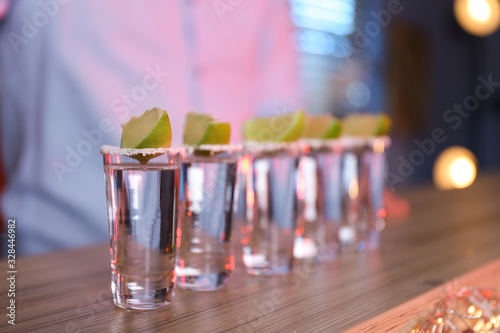 Mexican Tequila shots with salt and lime slices on bar counter © New Africa