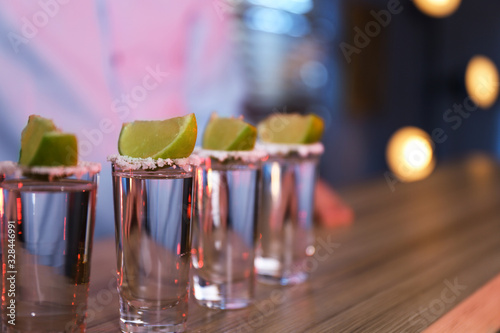 Mexican Tequila shots with salt and lime slices on bar counter