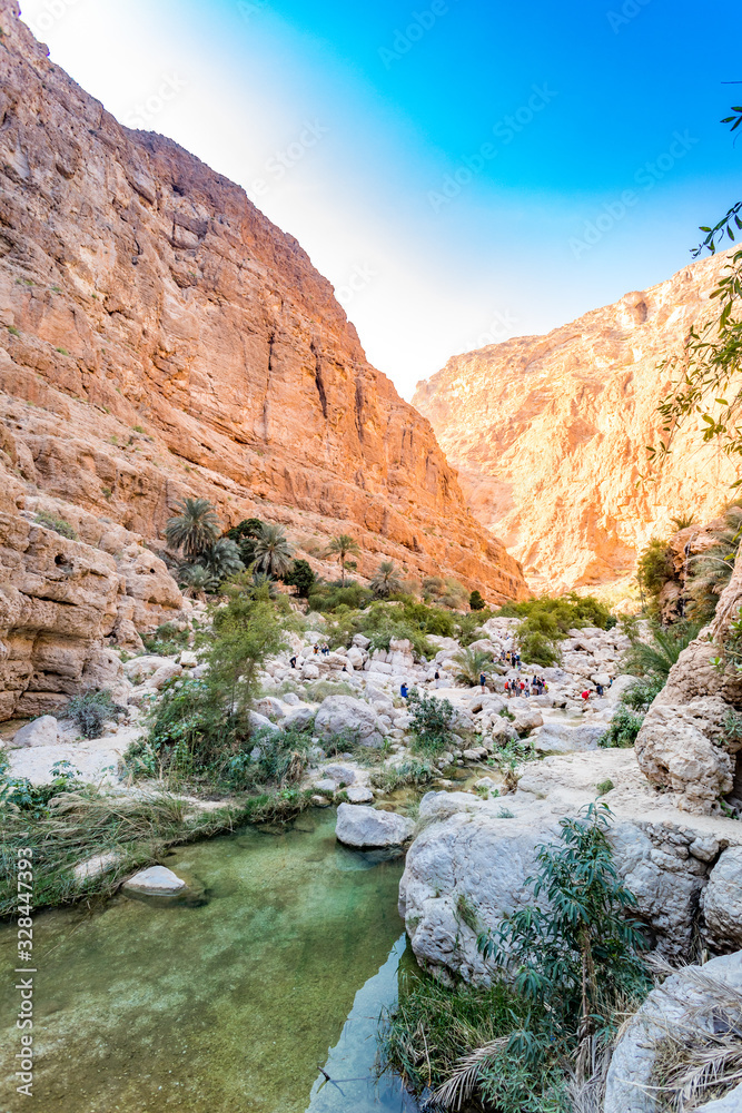 Wadi Shab river canyon with rocky cliffs and green water springs - Sultanate of Oman