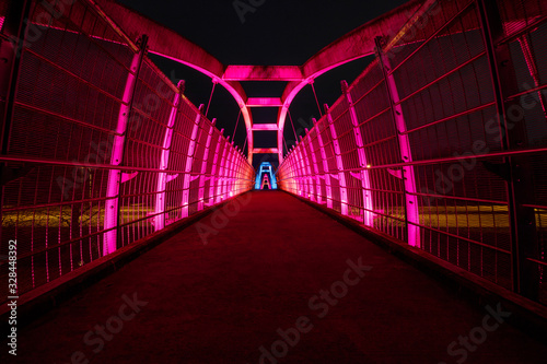 Obraz na płótnie Bright red LEDs illuminate pedestrian walkway over highway at night w salonie