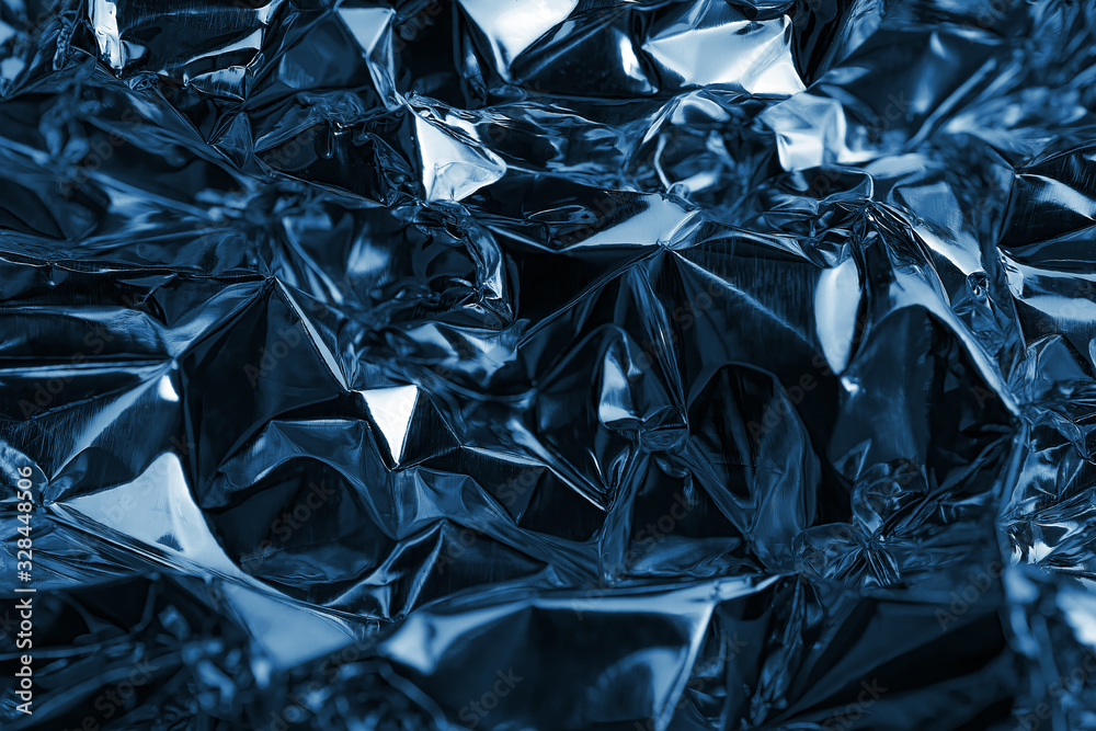 Shiny crumpled metal foil as blue background or texture Shiny crumpled metal foil as blue background or texture