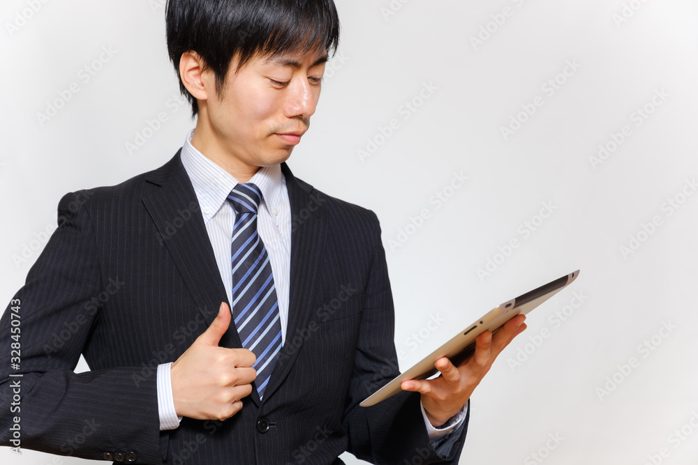 タブレットを持って親指を立てるスーツ姿の男性 タブレットを持って親指を立てるスーツ姿の男性
