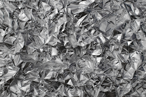 Shiny crumpled metal foil as silver background or texture