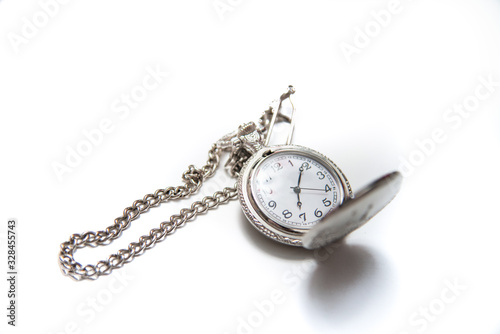 Vintage pocket watch with a chain on white isolated background.