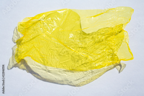 Billede på lærred Thin sheet of yellow colour cellophane with shiny crumpled surface texture  on w