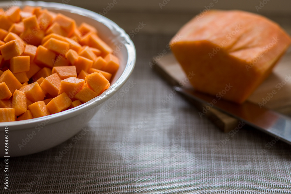 yellow pumpkin cut into cubes and put in a bowl yellow pumpkin cut into cubes and put in a bowl