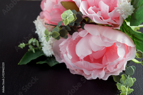 Fototapeta Naklejka Na Ścianę i Meble -  Pink artificial peonies on a black background.