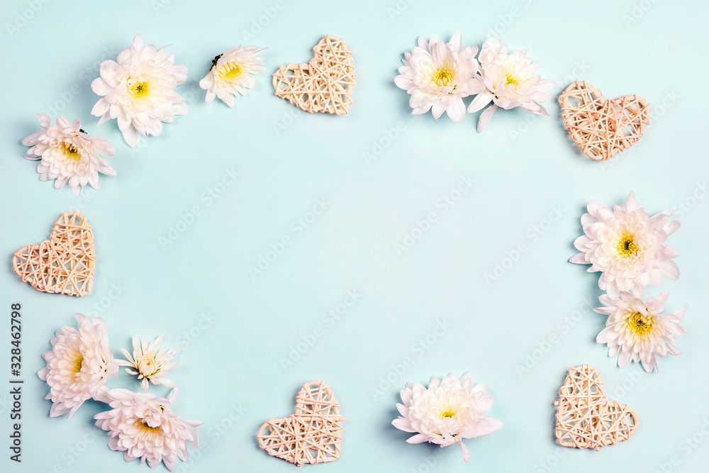 Frame of chrysanthemums and decorative hearts on a blue background.