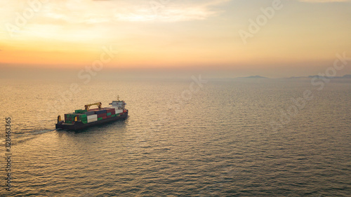 Aerial view from drone, a cargo vessel with peaceful sea in beautiful scenic sky. Professional business logistics and transportation of cargo ship.