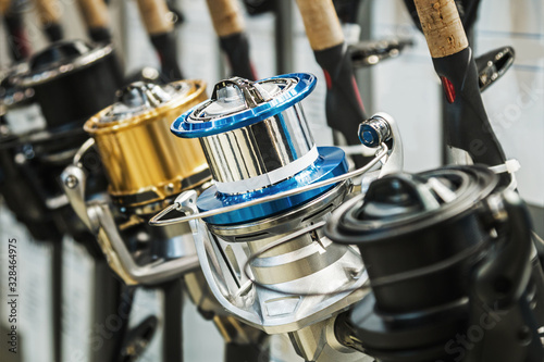 fishing reels of different sizes on the counter in the fishing store. Shallow depth of field © OlegDoroshin