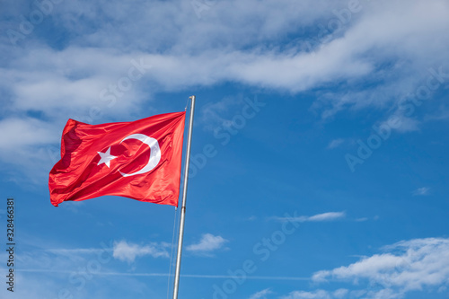 Turkish flag on a cloudy blue sky background.