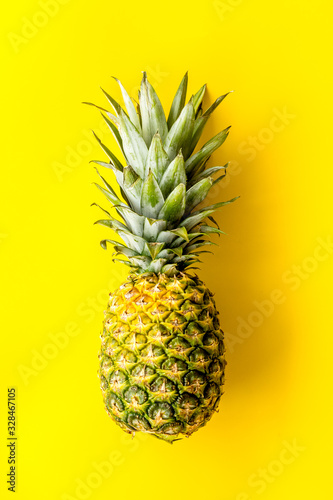 Pineapple - whole fruit - on bright yellow background top-down