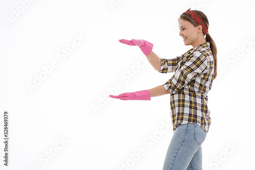 Portrait of happy female doing house duties wearing rubber gloves and holding cleaning equipment. Cheerful look. Hygiene, cleaning service concept. Isolated picture. White background.